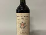 une bouteille de vin rouge posée sur une table blanche