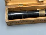 une boîte en bois contenant un télescope, posée sur une table