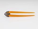 une photo montrant une paire de barrettes orange posées sur une surface blanche
