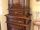 a tall wooden cabinet in the corner of a room