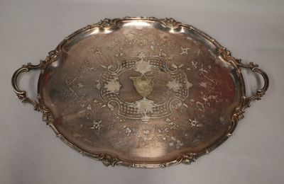 an antique silver tray with a design on it on a white surface