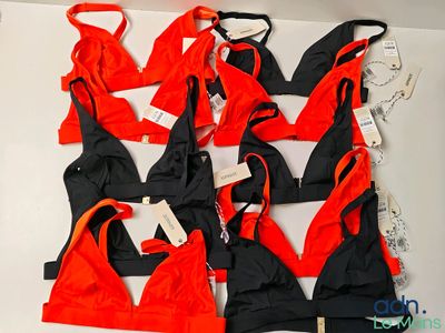 six red and black swimsuits on display on a white surface