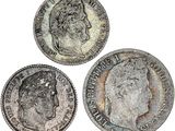 trois pièces d'argent sur lesquelles figurent respectivement la tête d'une femme et celle d'un homme