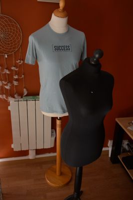 un mannequin et un t-shirt posés sur un support dans une pièce