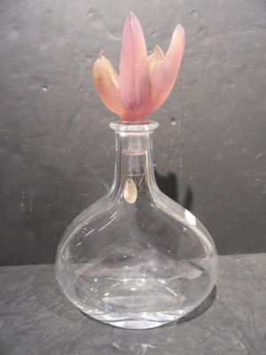 a glass vase with a flower in it on a table