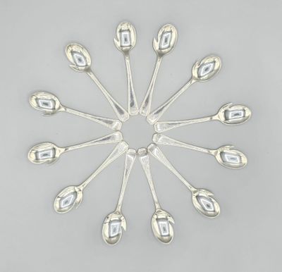 six silver spoons arranged in a circle on a gray surface