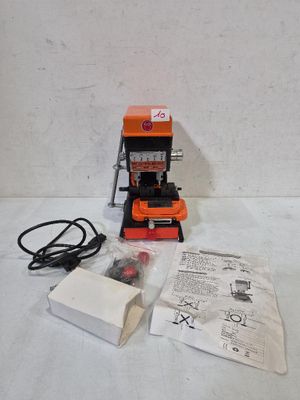une machine orange et noire posée sur une table blanche