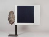 a rock on a stand with a picture frame on it