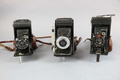 three old cameras sitting next to each other on a table