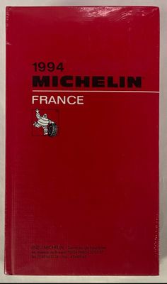 Le livre est rouge et blanc, avec des inscriptions noires.