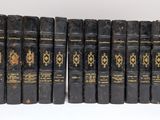 six vieux livres sont alignés sur une surface blanche