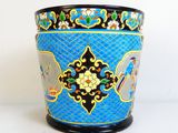 un vase bleu avec un motif sur une surface blanche