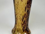 a brown and black vase sitting on a white table