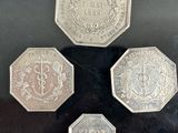 four different coins are on display in a glass case