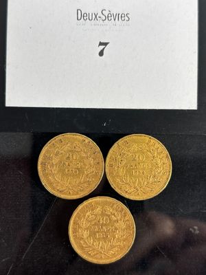 a close up of three gold coins sitting on top of a table