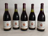 six bottles of wine are lined up on a table