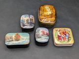 quatre petites boîtes ornées de motifs décoratifs, posées sur une table