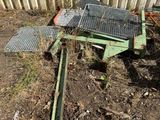 a metal cage on the ground next to a wooden fence