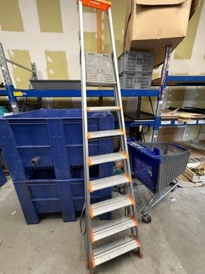 une photo d'une échelle dans un entrepôt avec des cartons