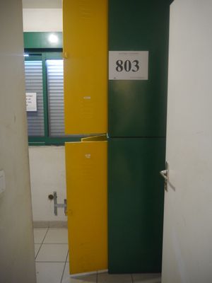 un casier vert et jaune dans une salle de bains, près d'une fenêtre