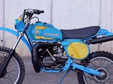 a blue and yellow dirt bike parked in front of a white wall