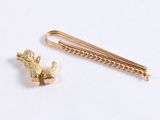 a gold pin with a dog on it next to a chain