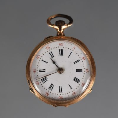 a gold pocket watch with roman numerals on the face