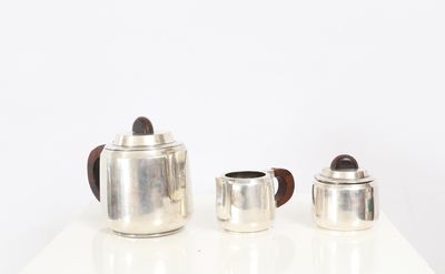 three silver teapots sitting on a white table