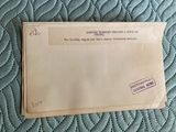 an old envelope sitting on top of a bed covered in blue sheets