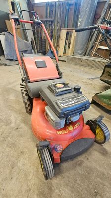 une photo d'une tondeuse à gazon rangée dans un garage