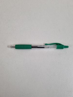 a green pen sitting on top of a white surface