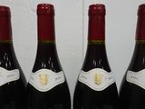 three bottles of red wine are lined up on a table