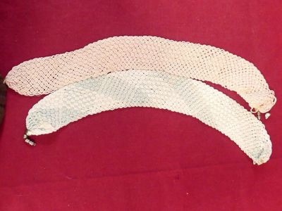 three pieces of white crochet on a red cloth