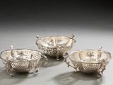 three silver plated bowls with handles and handles on a table