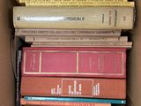 une boîte remplie de livres empilés les uns sur les autres