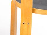 a wooden chair with a black seat on a white background