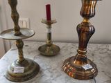 trois bougies posées sur une table où se trouve une lampe
