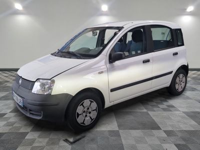 une photo d'une petite camionnette blanche garée sur un sol à damier