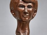 un buste en bronze représentant une femme coiffée d'un chapeau