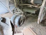 a wheel that is sitting on the ground next to a pile of junk