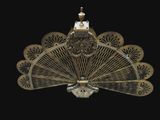 a large metal fan with a clock on top of it