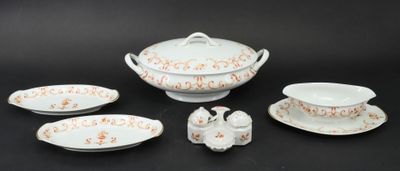 five pieces of white and orange china on a black table