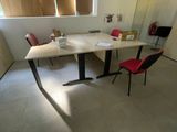 a table with two chairs and a desk with a laptop on it