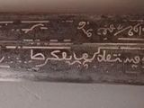 a knife with writing on it sitting on a table