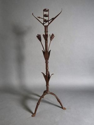 une image représentant un support métallique pour plantes sur lequel est posé un oiseau