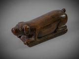 an old wooden figurine of a pig on a sled