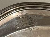 a close up of a silver plate with a coat of arms on it