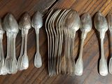 six spoons and six forks laid out on a wooden table