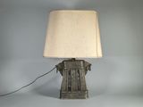 une lampe à l'ancienne surmontée d'un abat-jour blanc