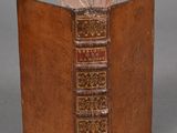 an old book sitting on top of a wooden table next to a gray wall